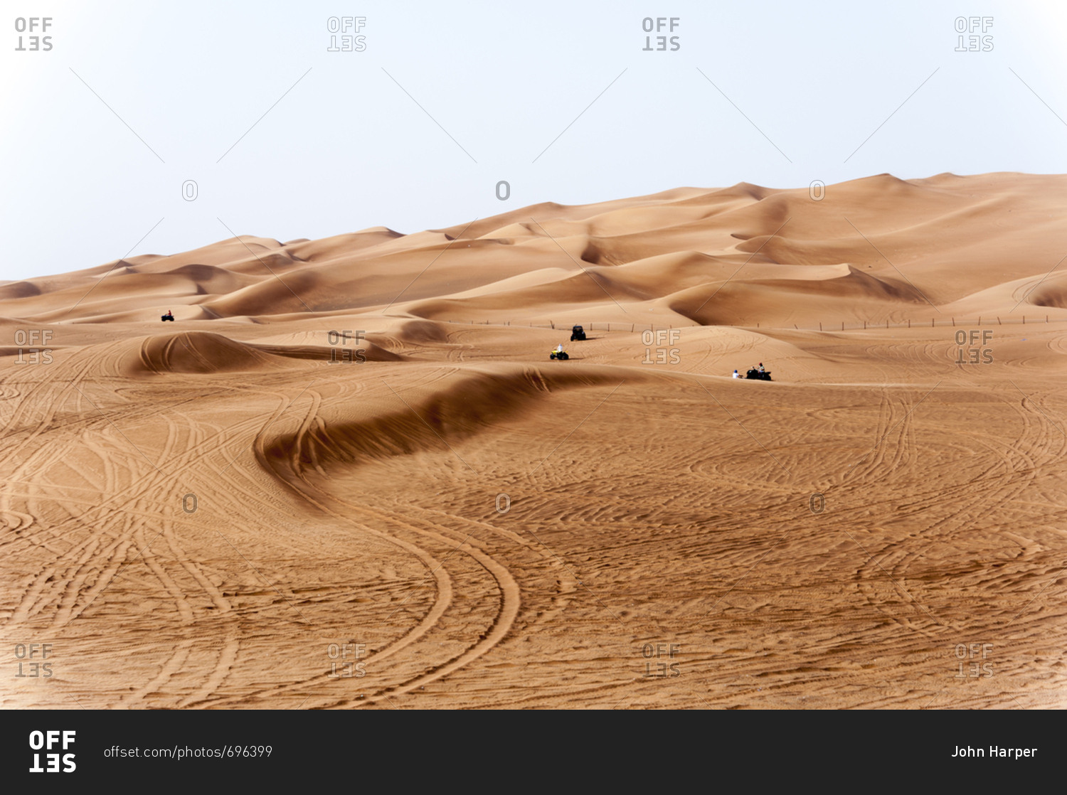 People riding all terrain vehicles in the sand dunes in the desert of Dubai, United Arab Emirates