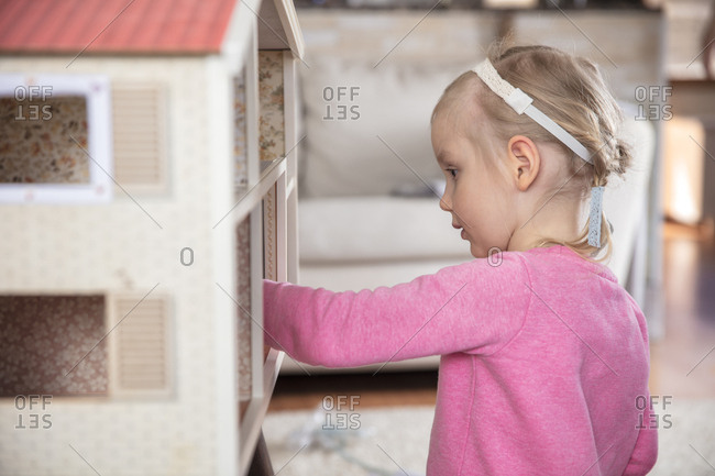 Girl plays with dollhouse
