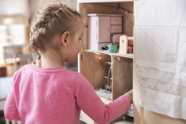 Girl plays with dollhouse