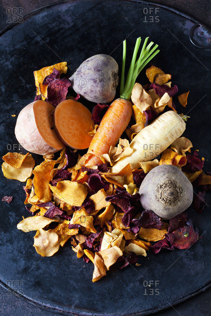 Sliced root vegetables and vegetable chips in bowl