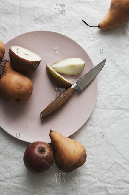 Bosc pears being sliced on a plate