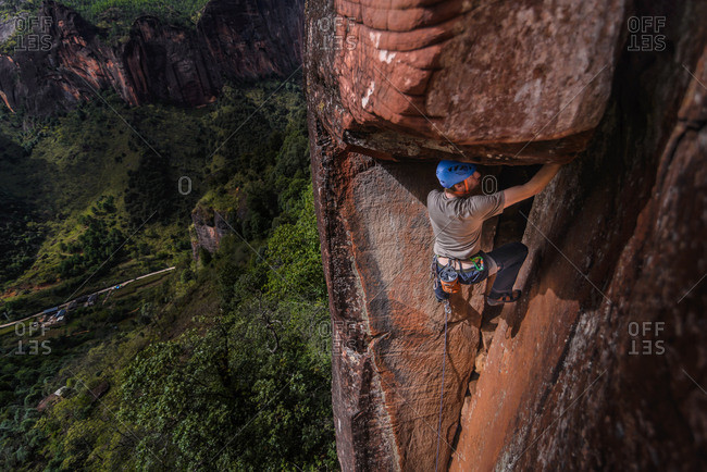 Rock climber climbing sandstone rock, elevated view, Liming, Yunnan Province, China