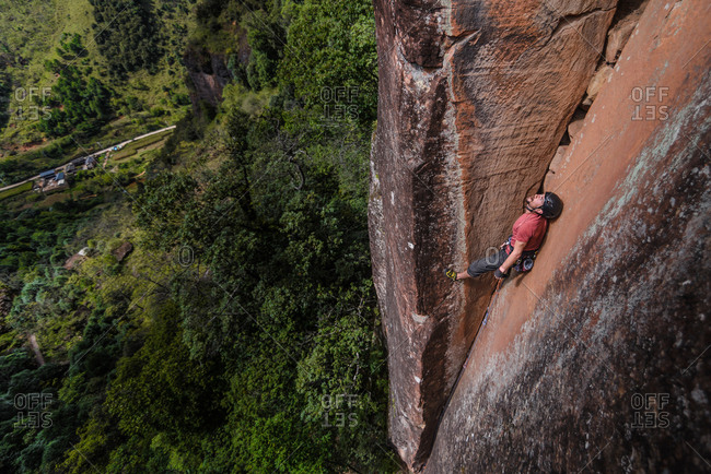 Rock climber climbing sandstone rock, elevated view, Liming, Yunnan Province, China