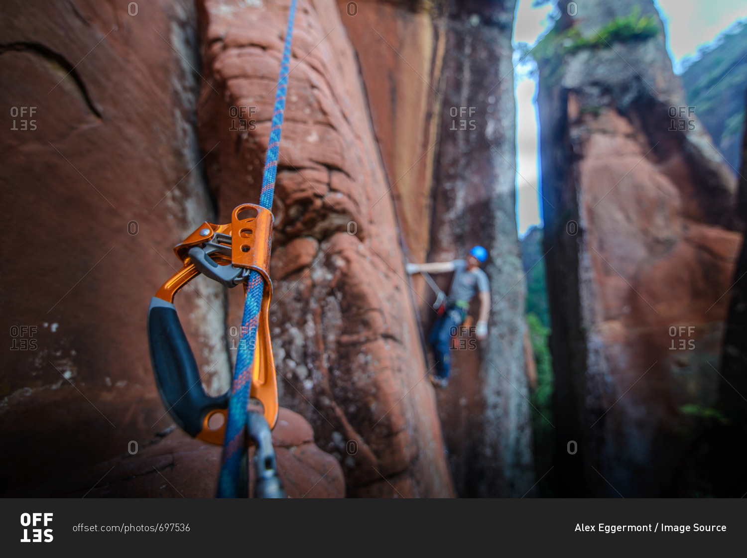 Rock climber climbing sandstone rock, focus on equipment in foreground, Liming, Yunnan Province, China