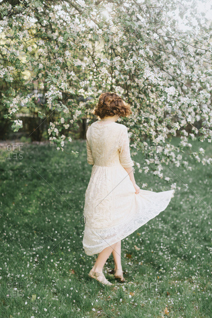 Woman twirling by blossom tree