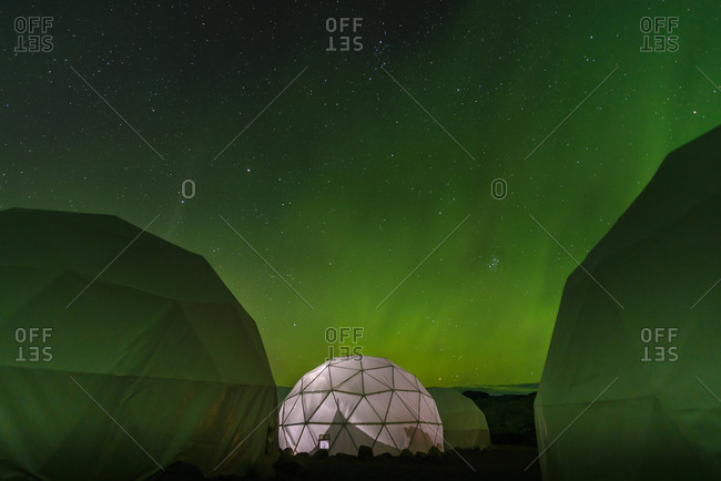 Lit up dome tent, Aurora Borealis in background, Narsaq, Vestgronland, Greenland