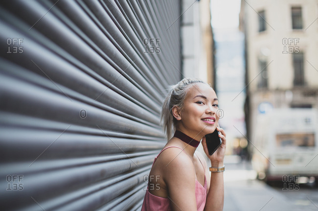 Young adult female on smartphone waiting for a friend
