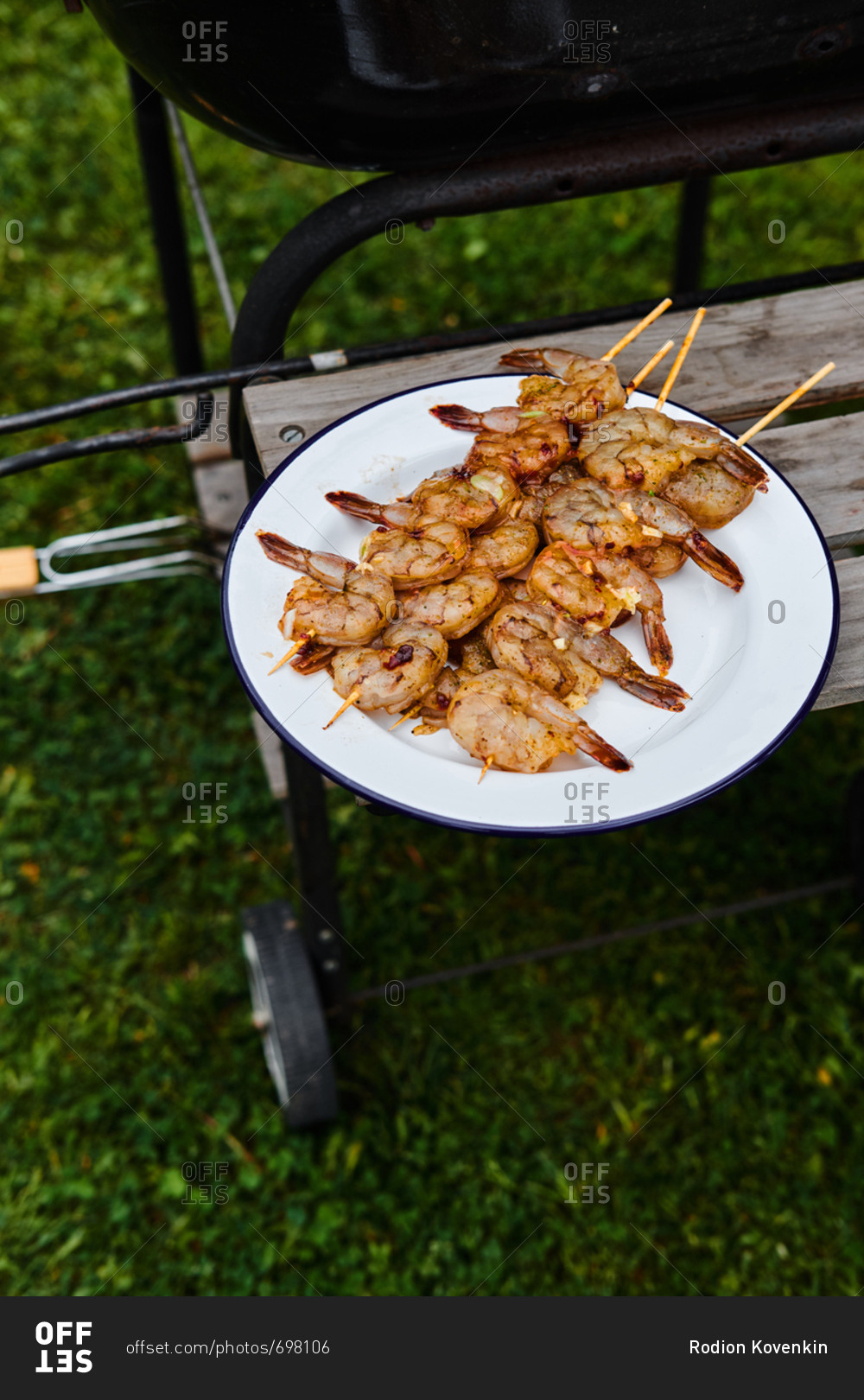 High angle view of plate of grilled shrimp on skewers cooling by the side of the barbecue