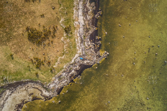 Aerial view of blue boat in abstract natural surrounding on the coastline of island of Vormsi in Estonia