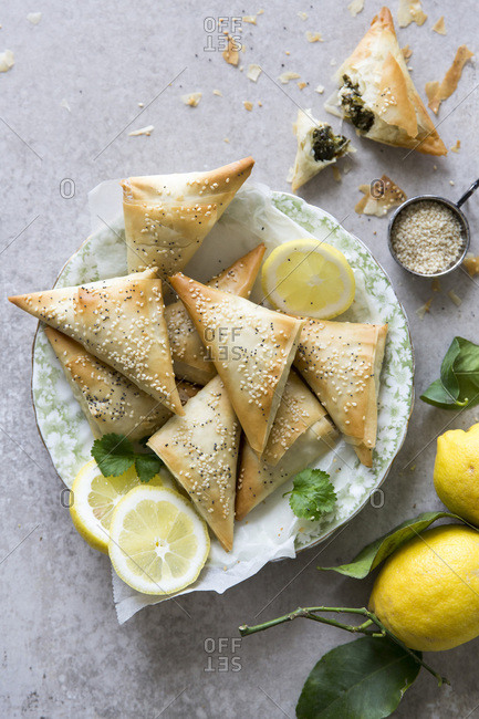 Spanakopita triangles or spinach pie is a Greek savory pastry. Ingredients include spinach, feta cheese, onions and eggs.