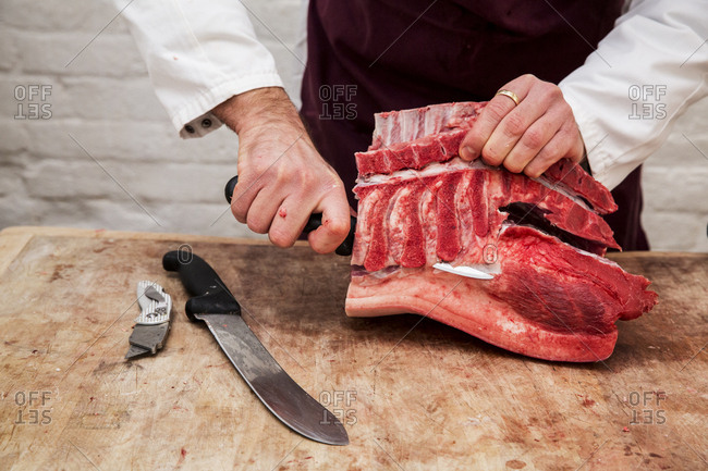 Man cutting meat on chopping board stock photo