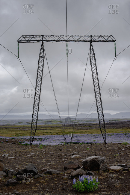 Electricity pylon on field against cloudy sky, Highlands, Iceland