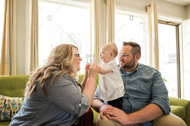 Mother smiling at baby in her husband's lap