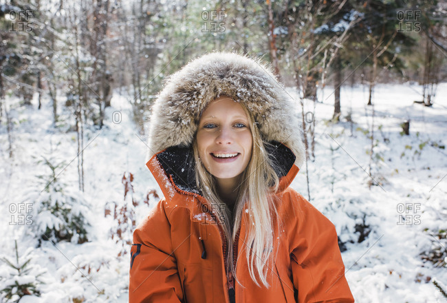 Portrait of smiling woman wearing fur coat in forest at Algonquin Provincial Park during winter