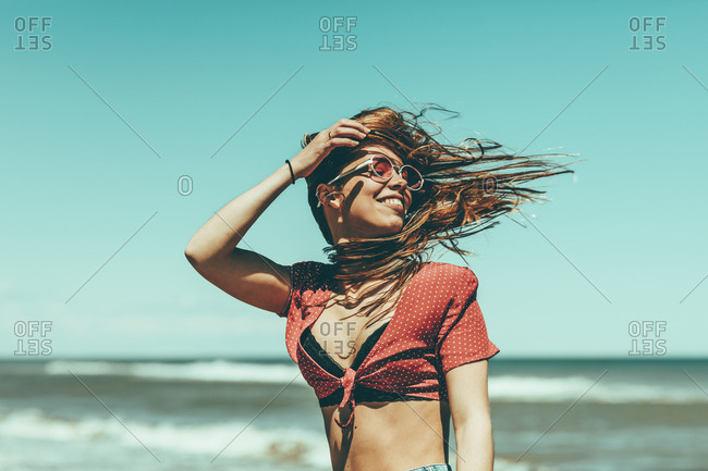 Portrait of a young woman with windblown hair at the beach