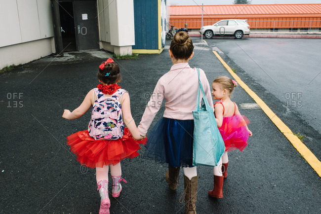 Three girls walking hand in hand in ballet outfits