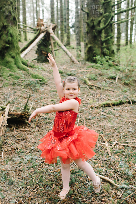 Young girl in a red ballet outfit in the woods