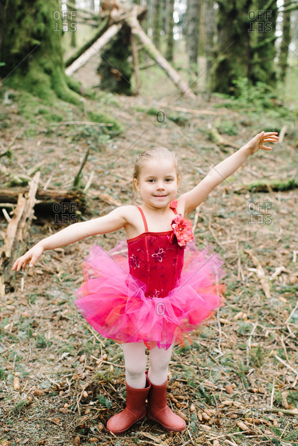 Little girl in a pink ballet outfit in the woods