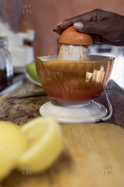 Brazilian woman juicing an orange for fresh juice at home