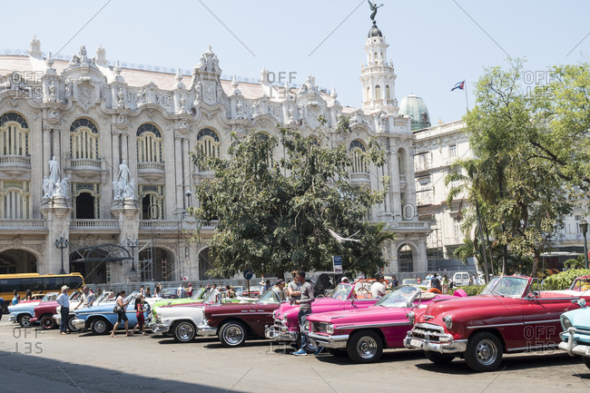 Havana, Cuba - March 21, 2015: Colorful vintage American cars parked in front of the ornate Grand Theater building