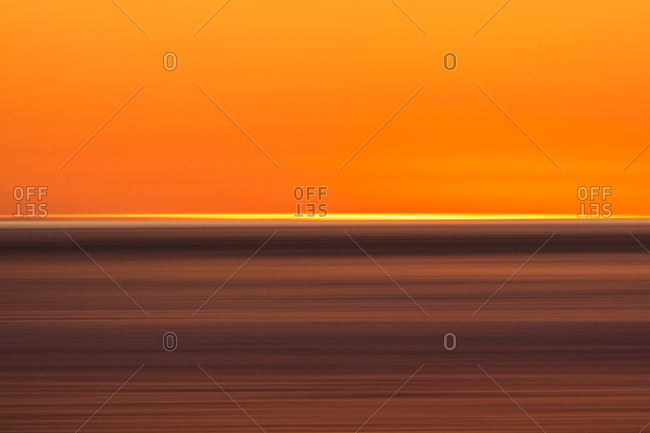 Abstract image of lines of gold and orange caused by setting sun over the ocean