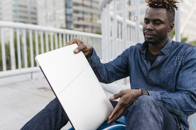 African man working with laptop at outdoors in Barcelona