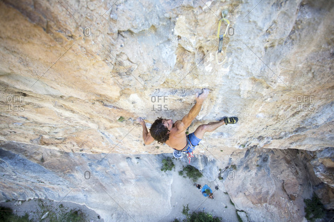 Young male climber challenging Collegats Gorge shirtless, Pobla de Segur, Lleida, Spain