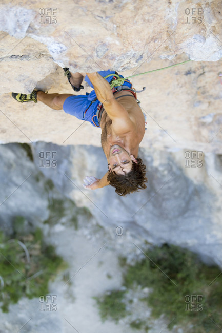 Male climber looking up while challenging Collegats Gorge shirtless, Pobla de Segur, Lleida, Spain