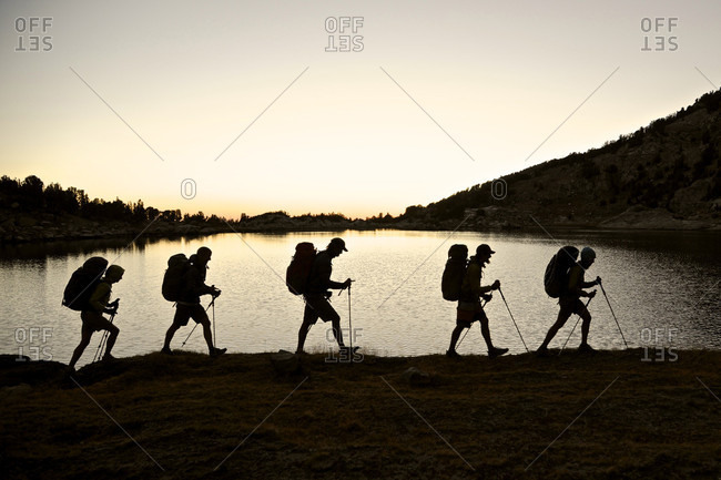 Backpackers hiking to Deer Lakes on Mammoth Crest at sunset on two-week trek of Sierra High Route in John Muir Wilderness in California, USA