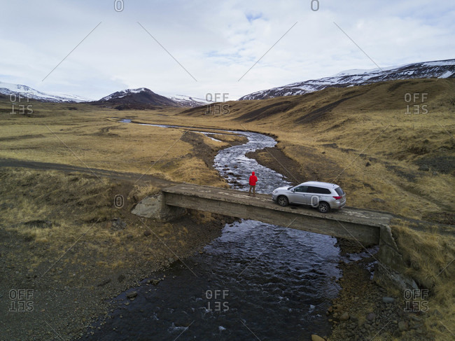 Adventure looking into Westfjords landscape from bridge with SUV in Iceland