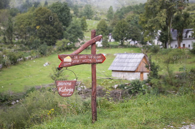 Rural scene with sign pointing way to mountain farm producing cheese in Triglav, Slovenia