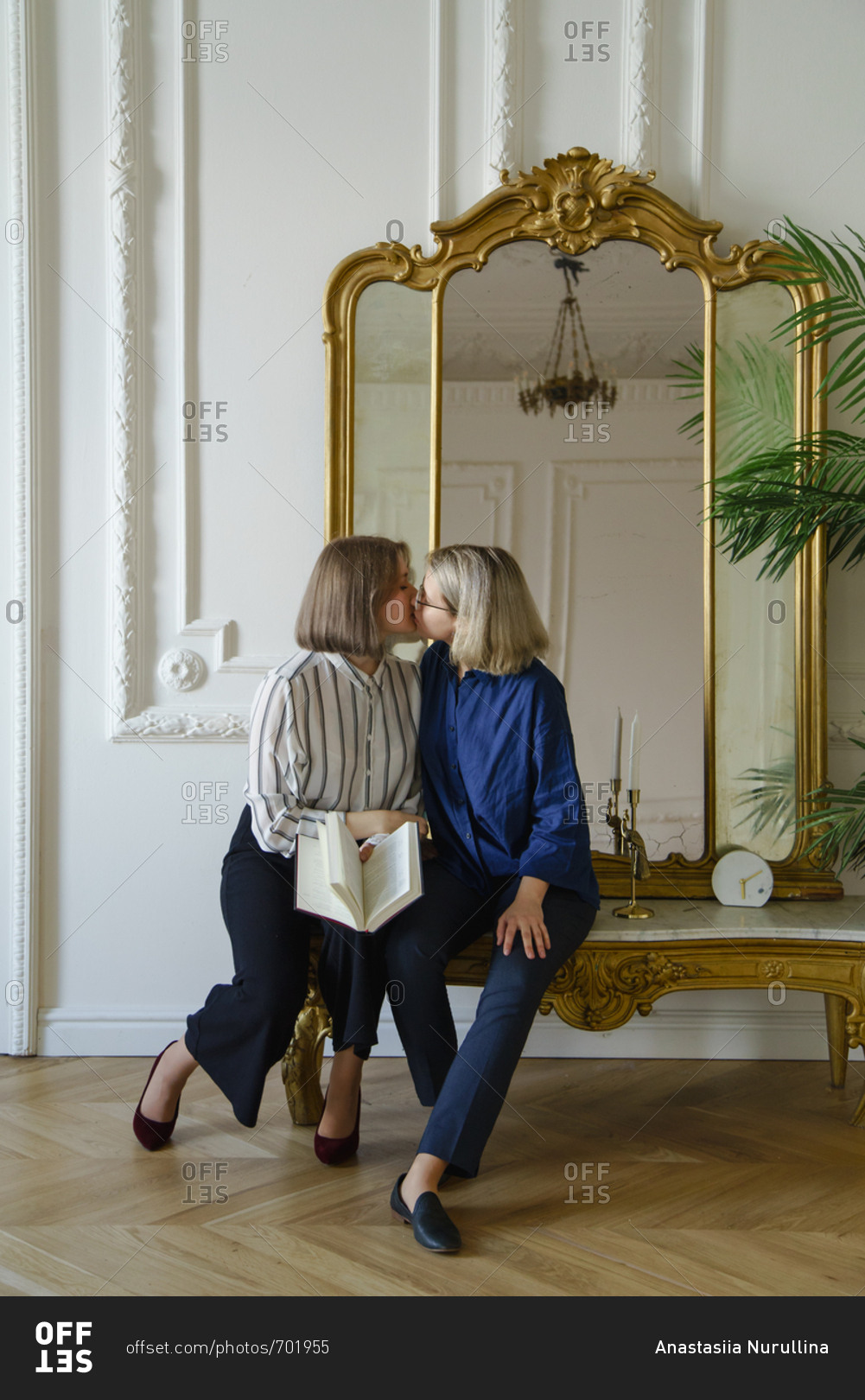 Lesbian couple kissing next to vintage mirror