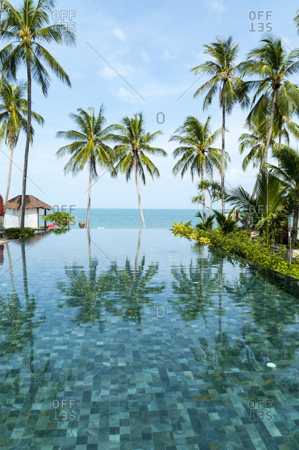 Palm trees reflected in infinity pool at luxury resort on Koh Samui Island in Thailand