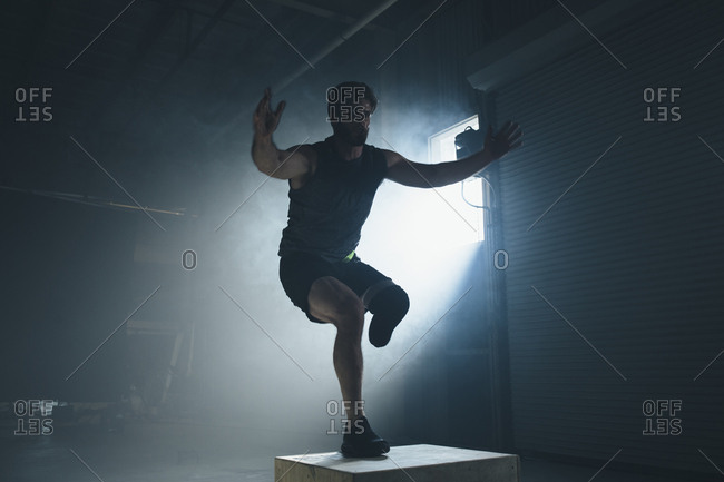 Adaptive athlete exercising on box in gym