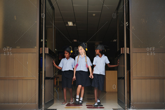 Three Girls Walking Through Doors After Graduation Stock