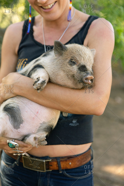 Close up of a woman holding spotted baby pig
