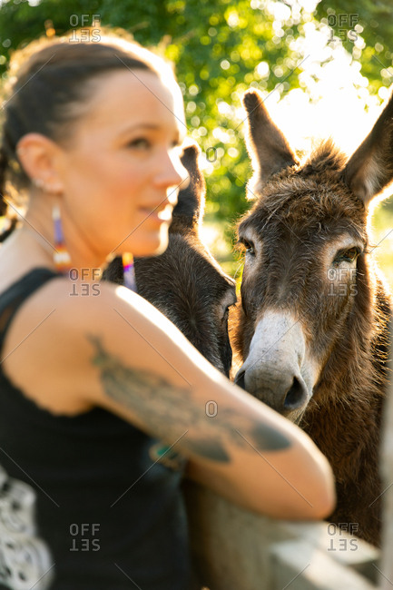 Woman standing by donkeys on a farm