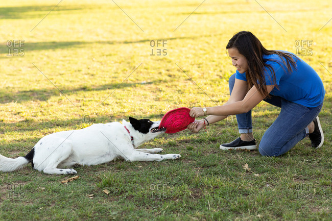 Woman playing toy disc with her dog