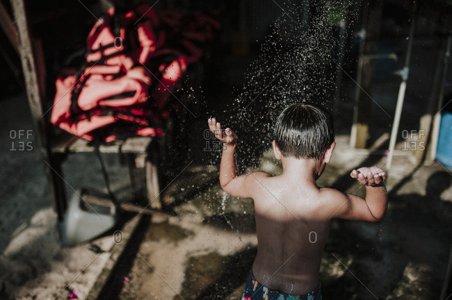 Back of boy at outdoor shower on Malaysian coast