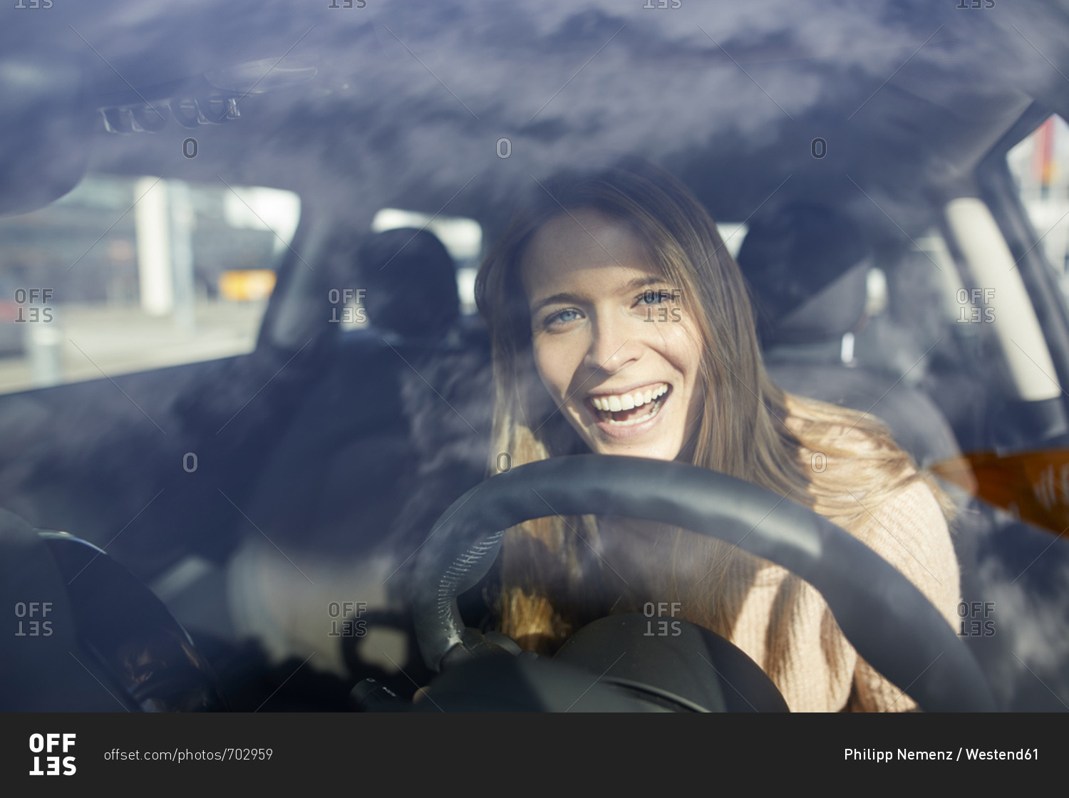Portrait of laughing young woman in car