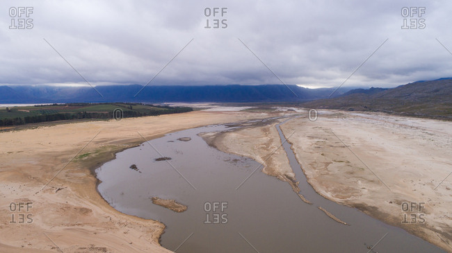 Aerial image over a dry Theewaterskloof dam during the worst drought in decades in the Western Cape of South Africa with massive patches of barren earth exposed