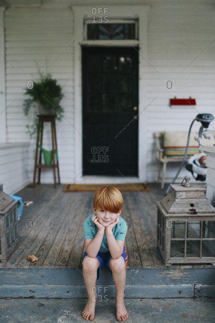 Boy sitting on the front porch