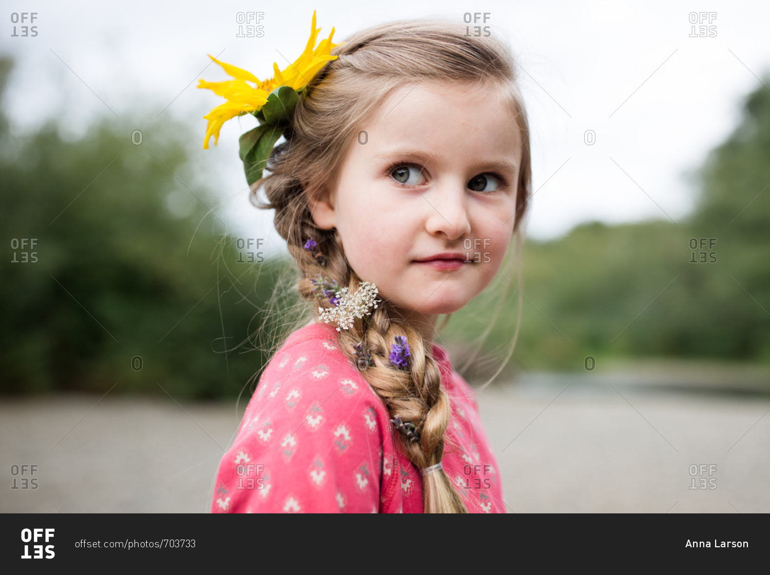 Portrait of a young blonde girl with a yellow flower in her hair