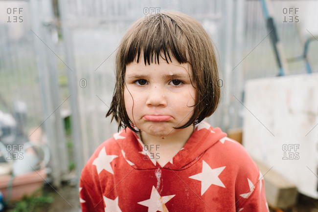 Portrait of little girl pouting in greenhouse