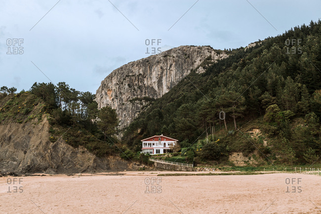 A house in the middle of the mountains on the beach