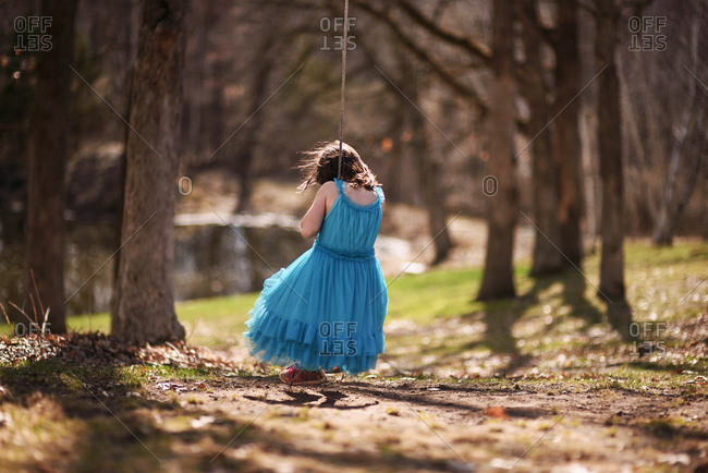 Young girl playing on an backyard swing