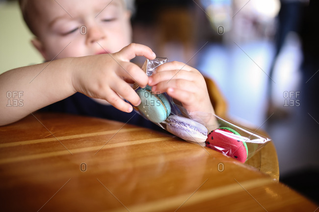 Toddler boy opening package of cookies
