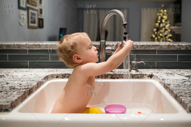 Baby Bathing In Kitchen Sink Stock Photo Offset