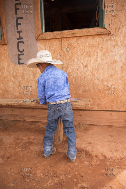 Monument Valley, Utah, USA - May 6, 2018: Boy wearing a cowboy hat working on a puzzle outside of tourist business