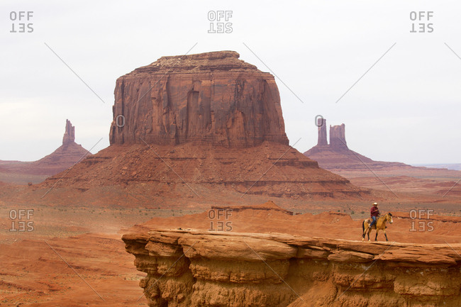 Monument Valley, Utah, USA - May 6, 2018: American Indian riding horse on mesa